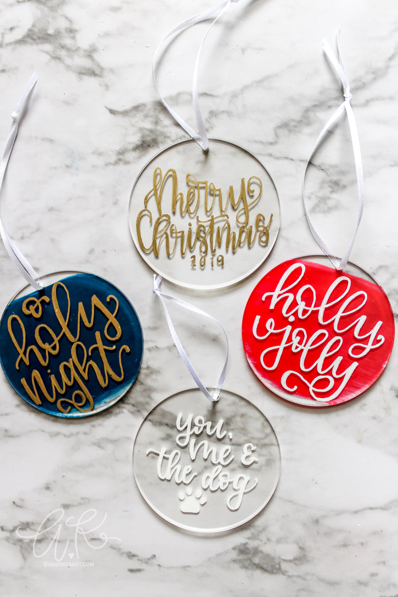 overhead photo of 4 painted acrylic ornaments on a marble background