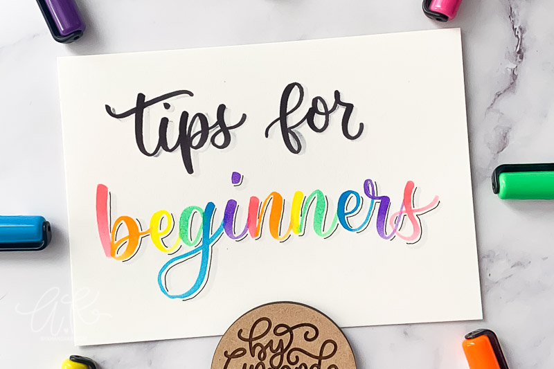 Zoomed in tips for beginners calligraphy on paper with bright colored markers.