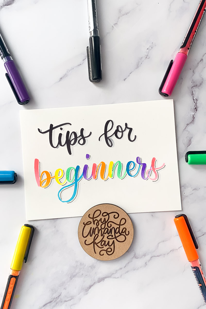 tips for beginners calligraphy on paper with bright colored markers on a marble backdrop