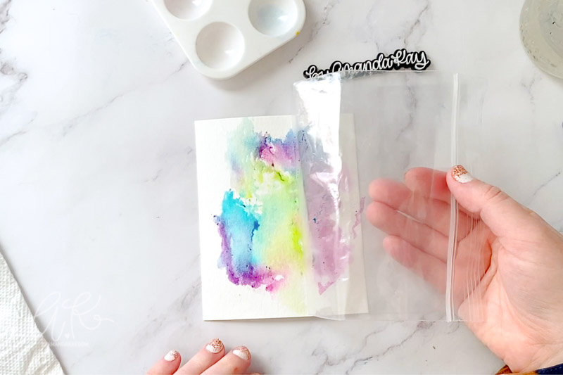 Peeling up the plastic bag from paper after watercolor smoosh.